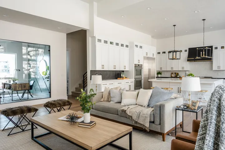Spacious interior featuring wood-finish flooring, a contemporary kitchen with white cabinetry and stainless steel appliances, a large center island, and recessed lighting