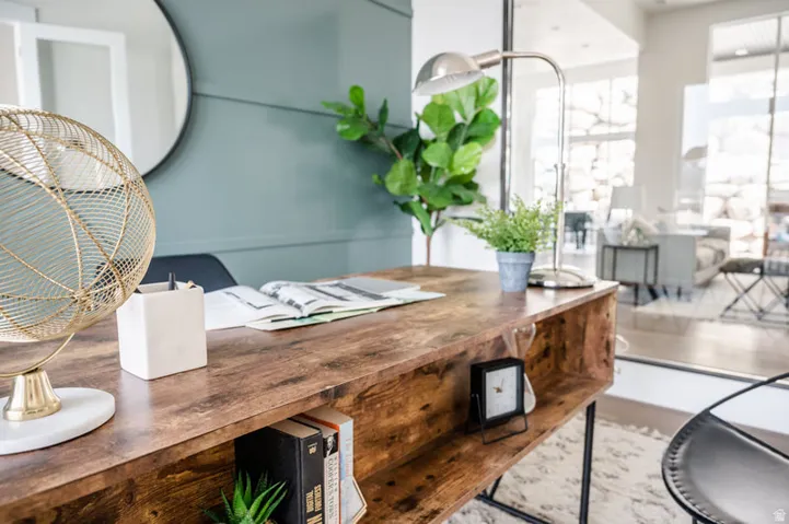 Wood-finish desk with integrated shelving, set against a paneled accent wall with a circular mirror