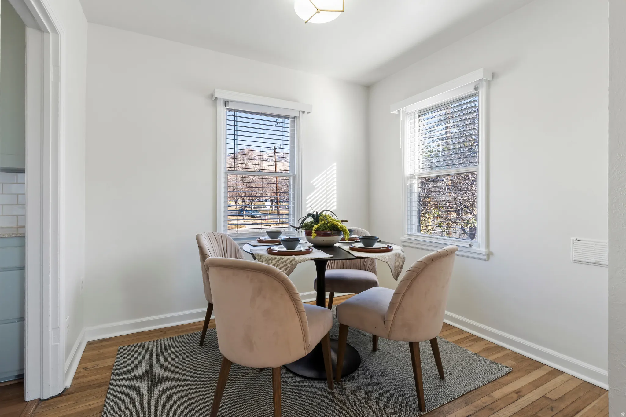 Bright dining area featuring wood-finish flooring and white baseboards