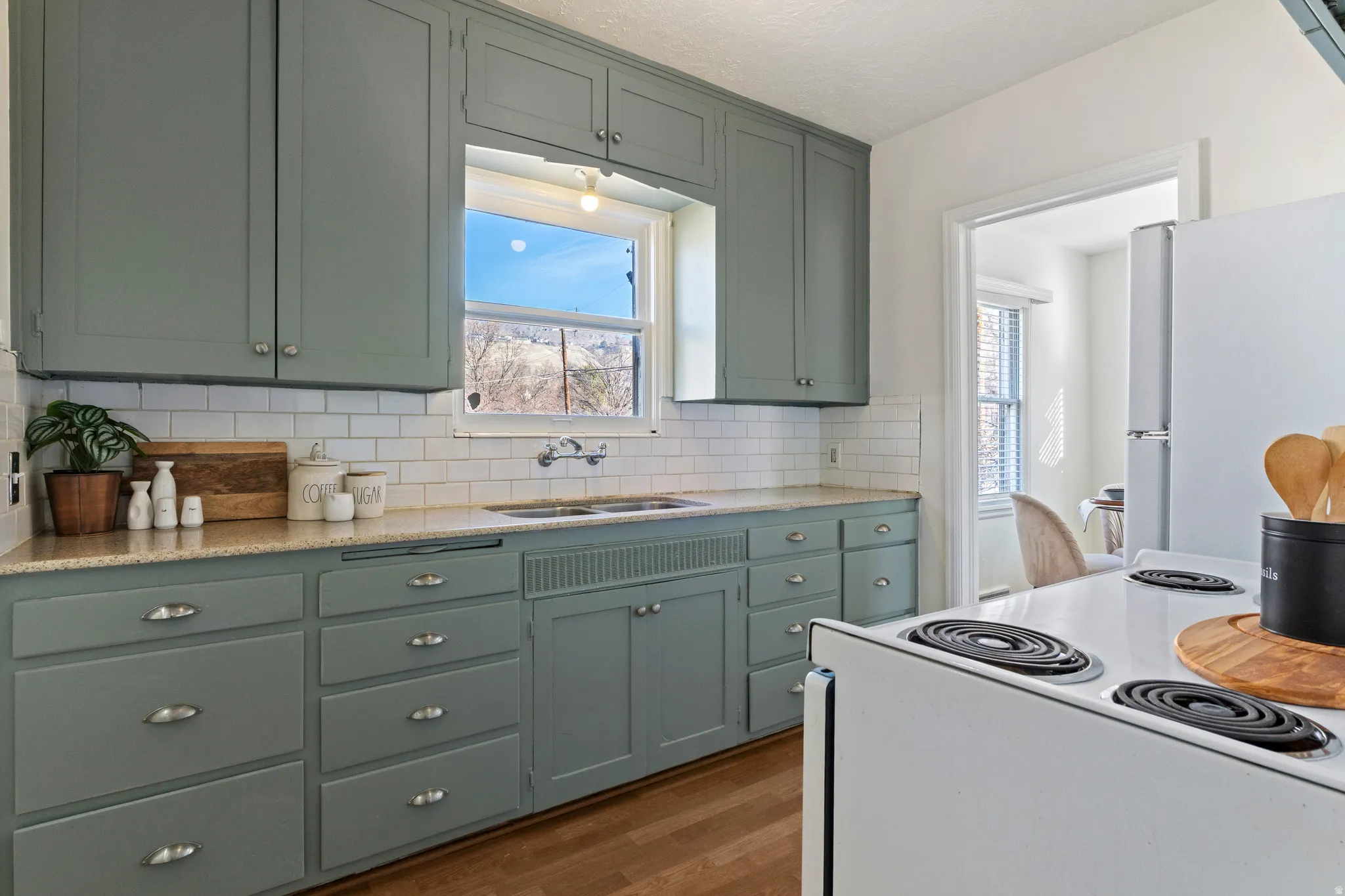 Kitchen featuring ample cabinetry, subway tile backsplash, and a double-basin sink