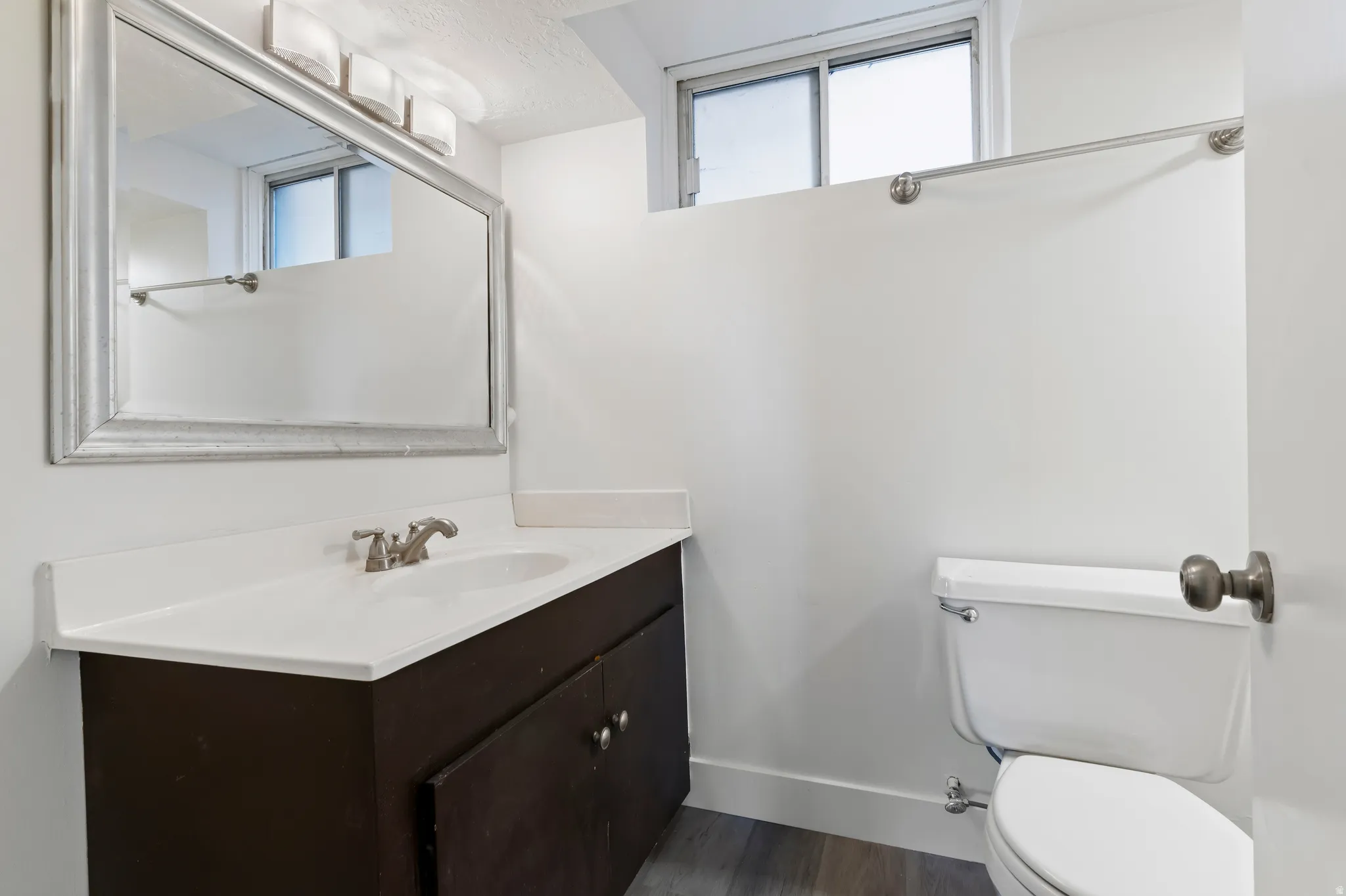 Bathroom featuring a dark wood-finish vanity with a white countertop and integrated sink
