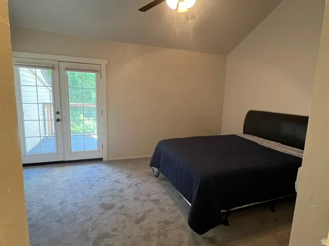 Primary bedroom featuring a vaulted ceiling and deck access thru French doors,