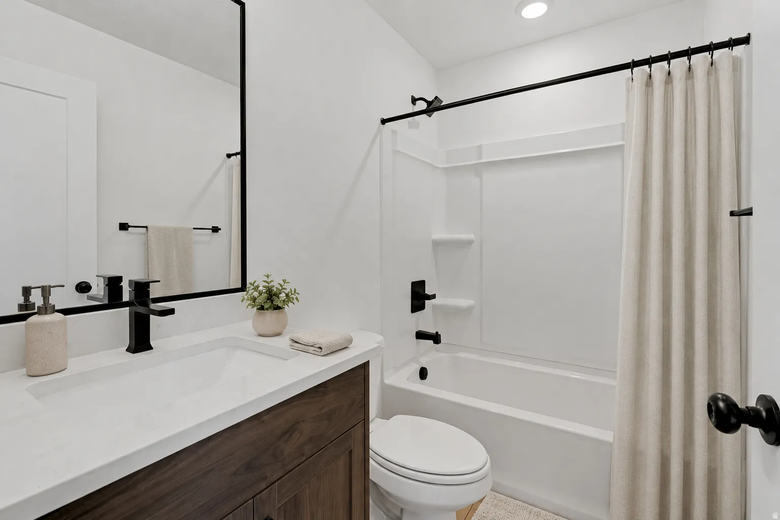 Modern bathroom featuring a wood-finish vanity with a white countertop and integrated sink