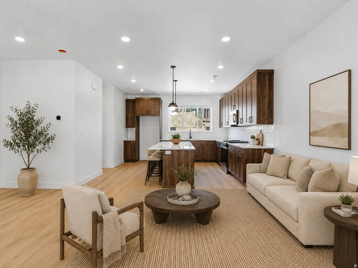Open-concept living space featuring wood-finish flooring, recessed lighting, and white baseboards