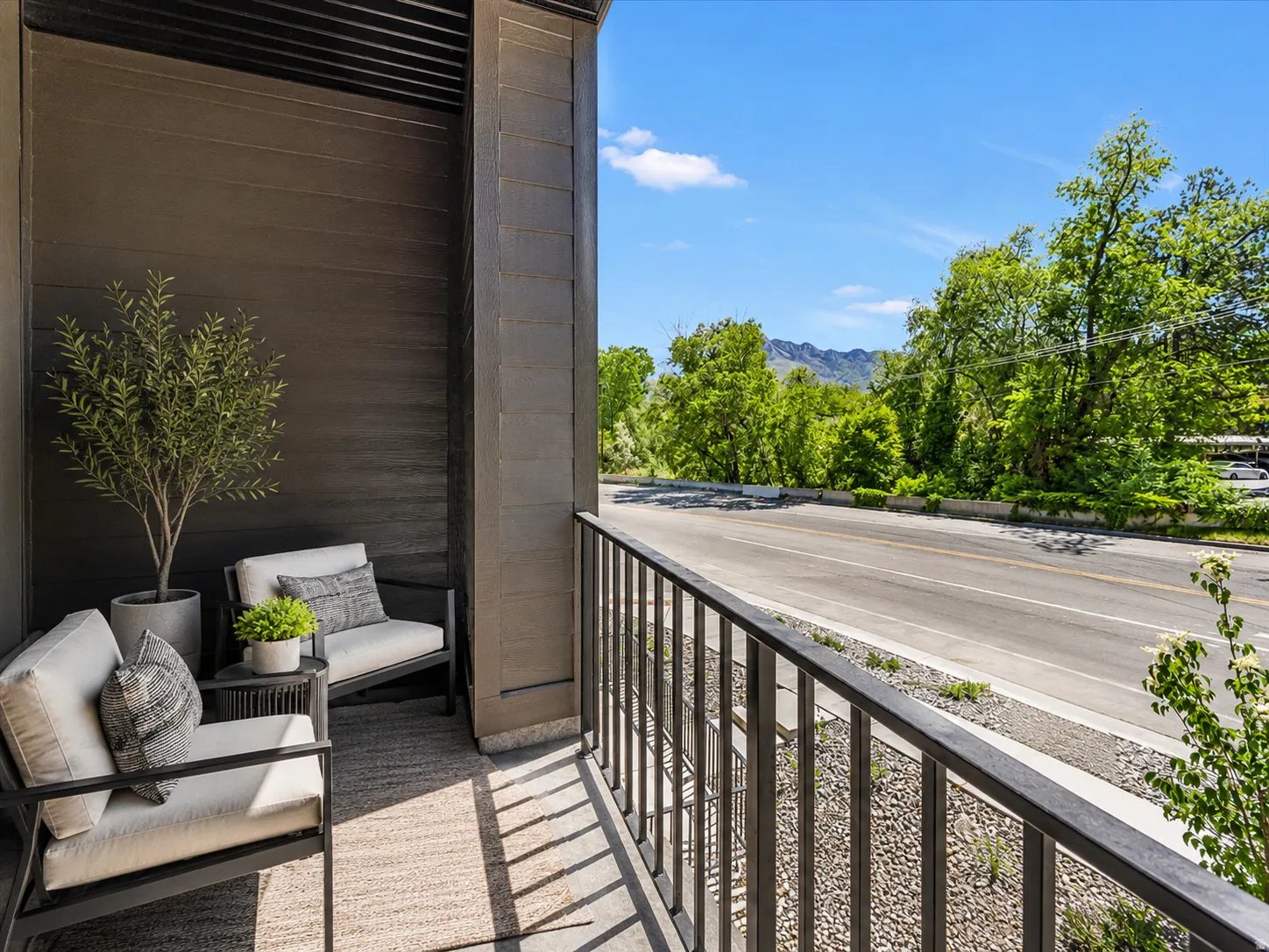 Private balcony featuring a metal railing and dark horizontal siding