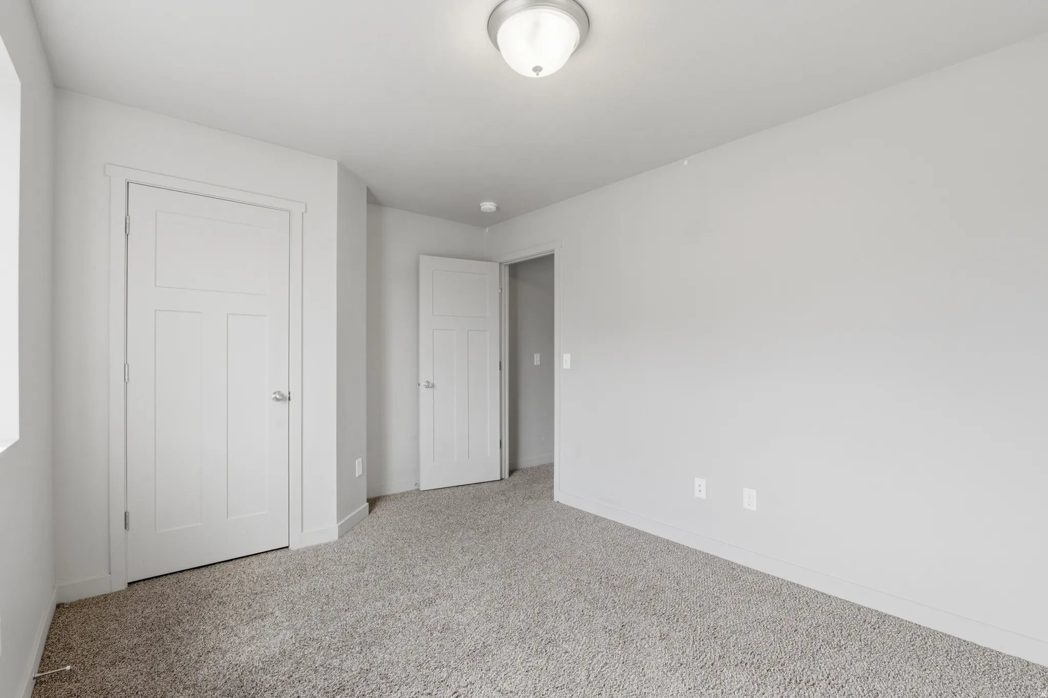 Neutral-toned wall finishes complement the grey carpeted flooring