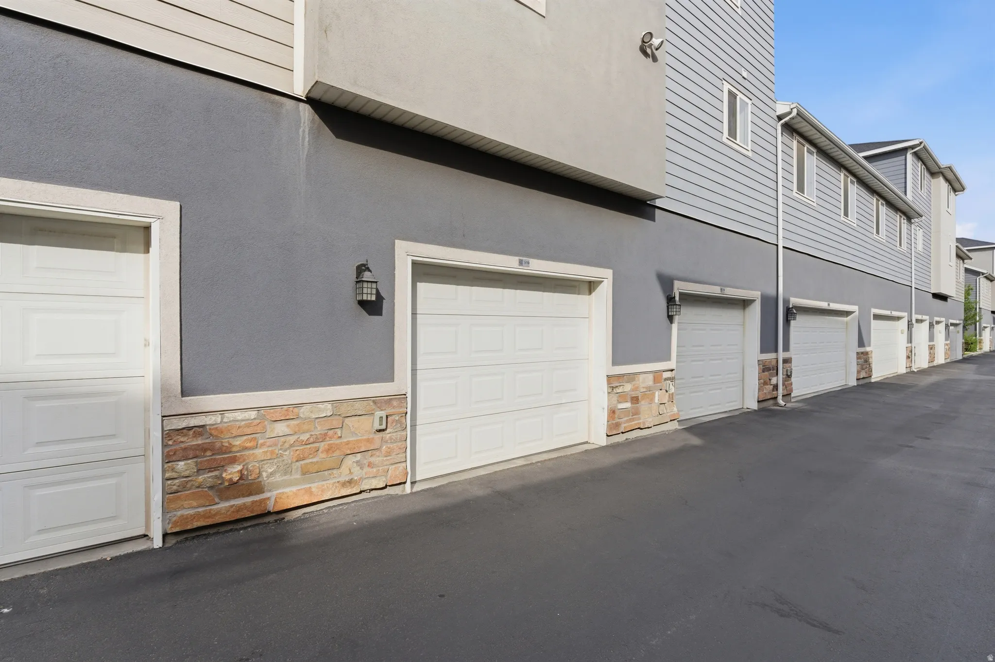 Exterior garages featuring panel doors and integrated lighting