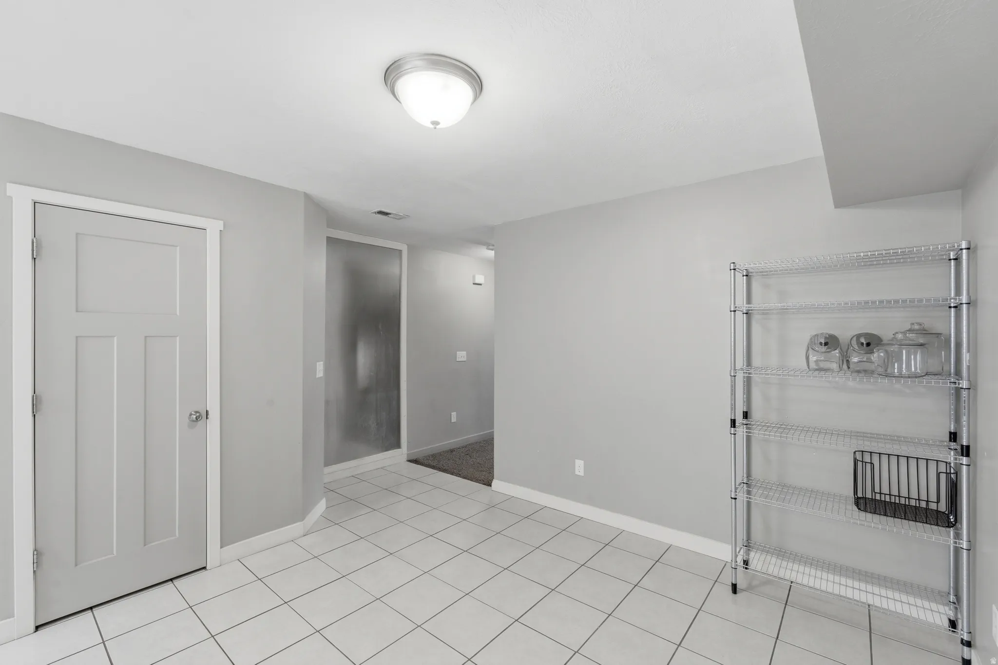 Neutral tone walls with white trim, complementing the white square tile flooring