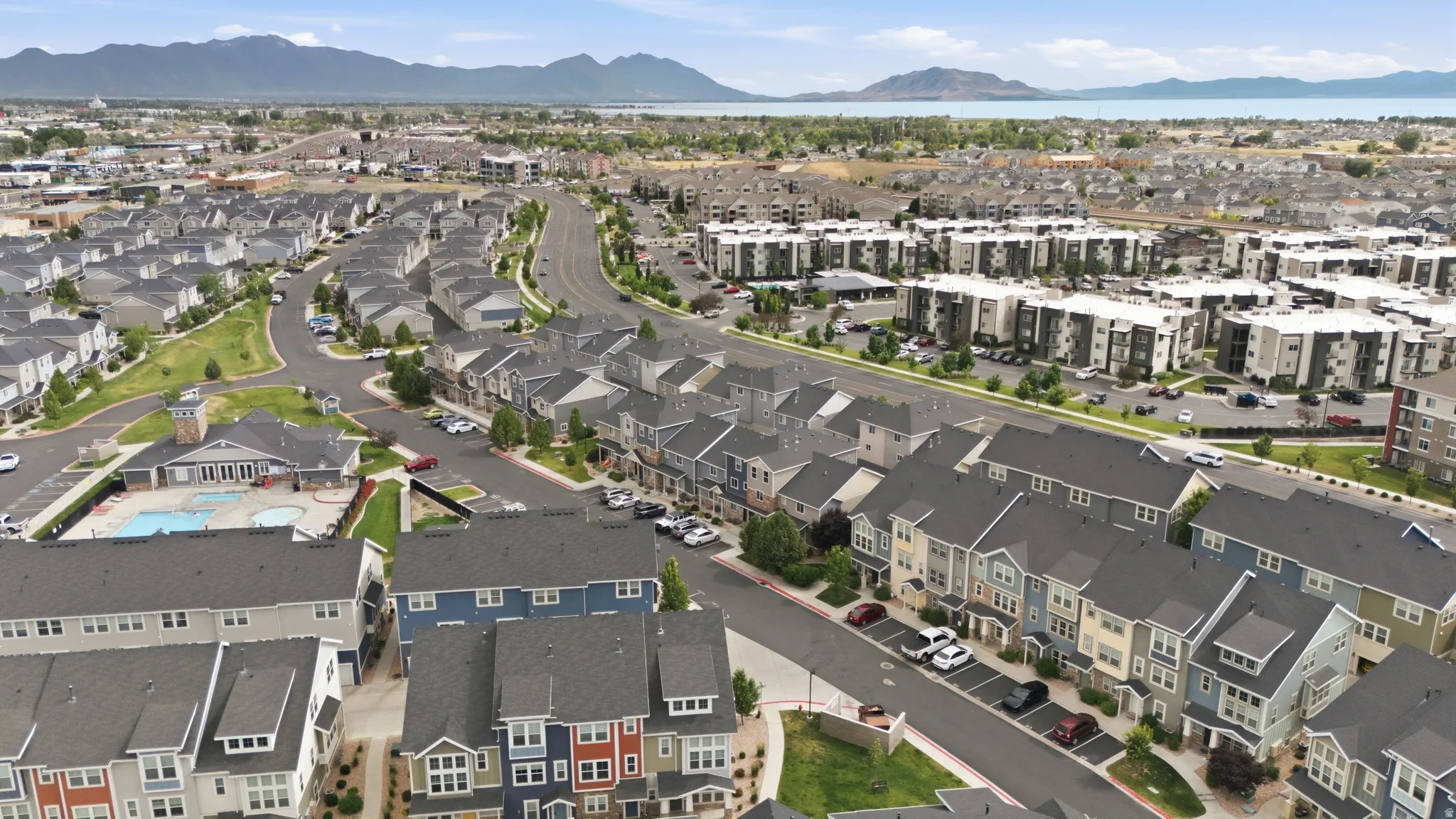 Aerial overview of a residential development featuring varied housing styles including townhomes and multi-story apartment buildings