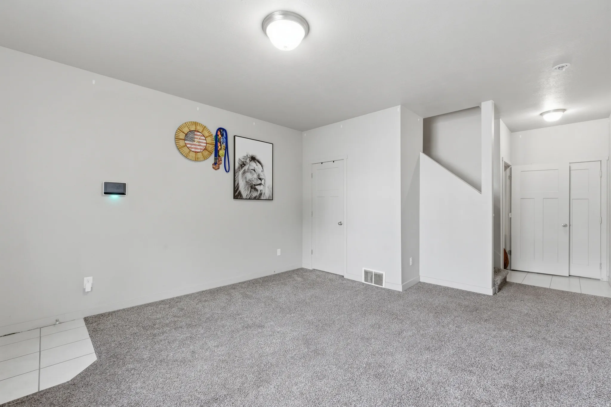 Spacious living area featuring neutral-toned carpeting, light gray walls, and recessed lighting
