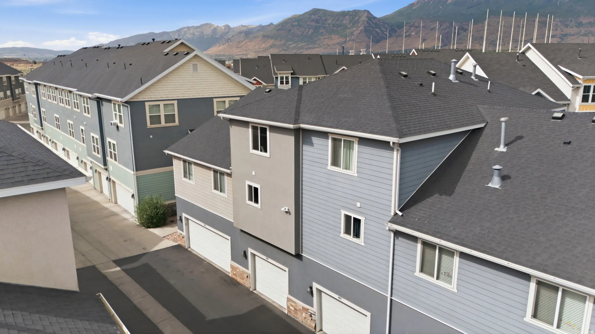 Multi-story residential buildings featuring varied siding materials and attached garages