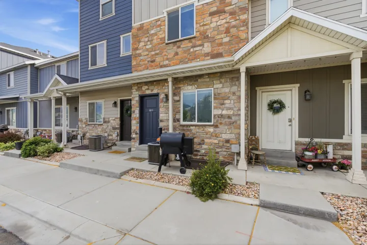 Townhome exterior featuring varied siding materials including stone veneer, vertical siding, and horizontal siding