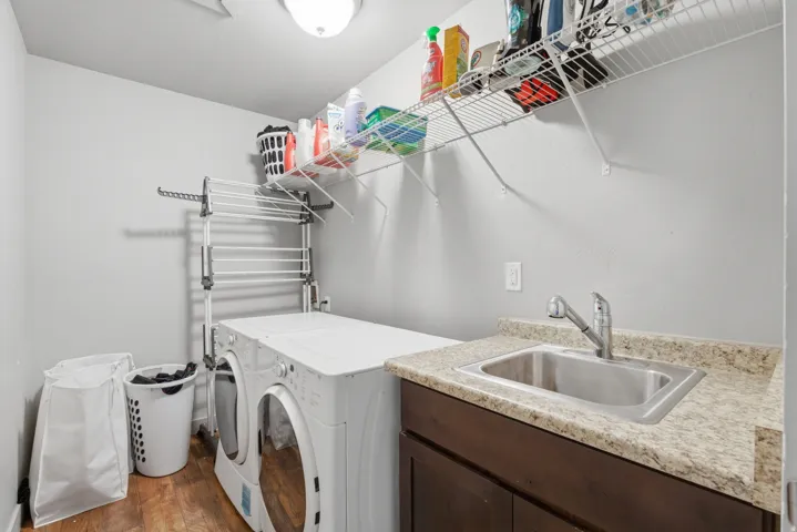 Dedicated laundry space featuring wood-finish flooring and light gray wall paint