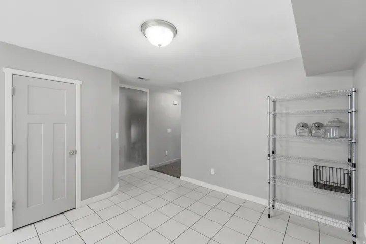 Neutral tone walls with white trim, complementing the white square tile flooring