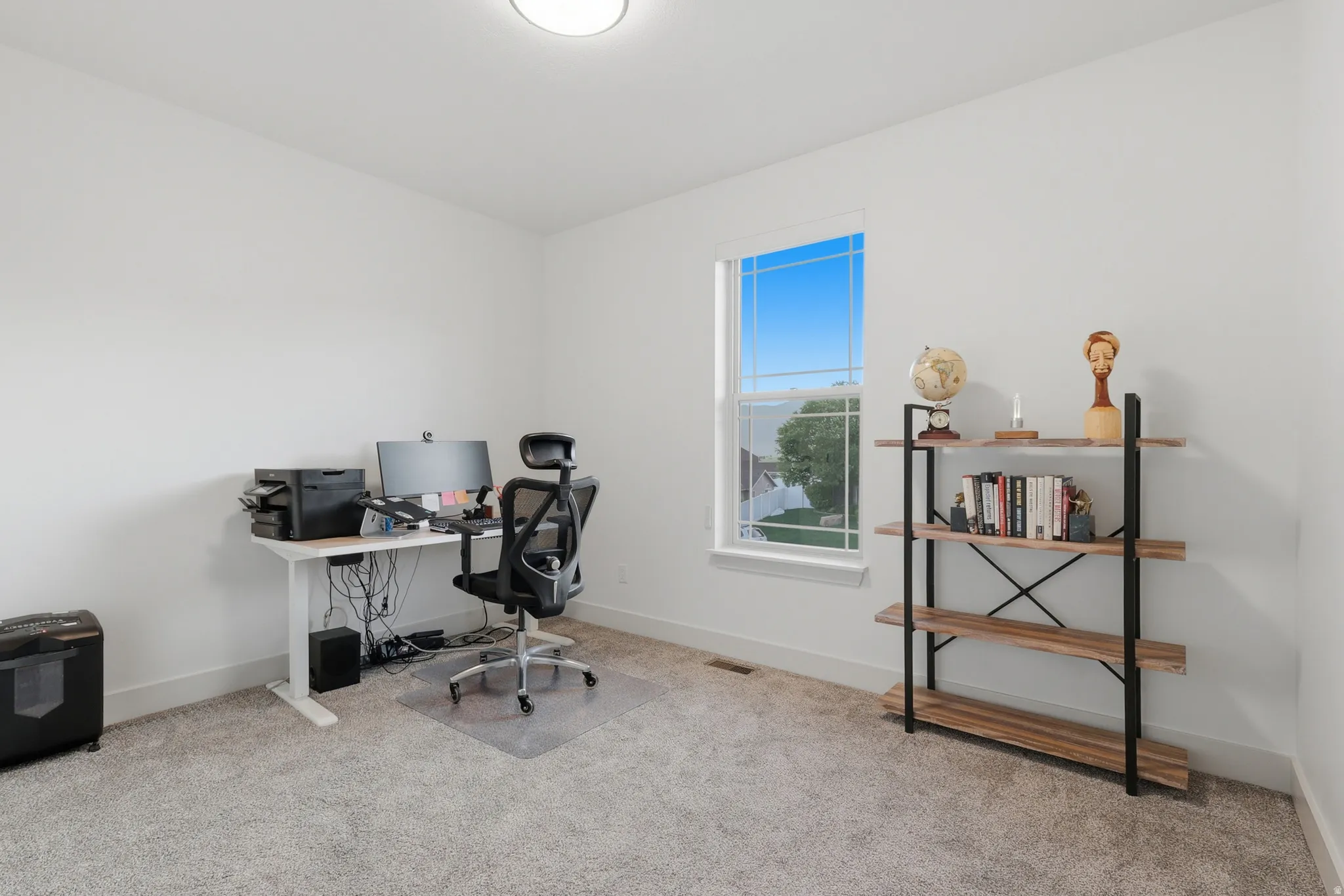 Room featuring a large window, light-colored walls, and neutral carpet flooring