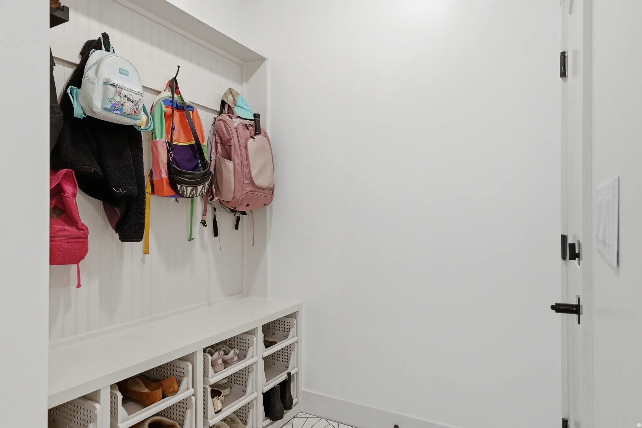 Built-in mudroom bench with beadboard backing, integrated storage cubbies, and overhead hooks