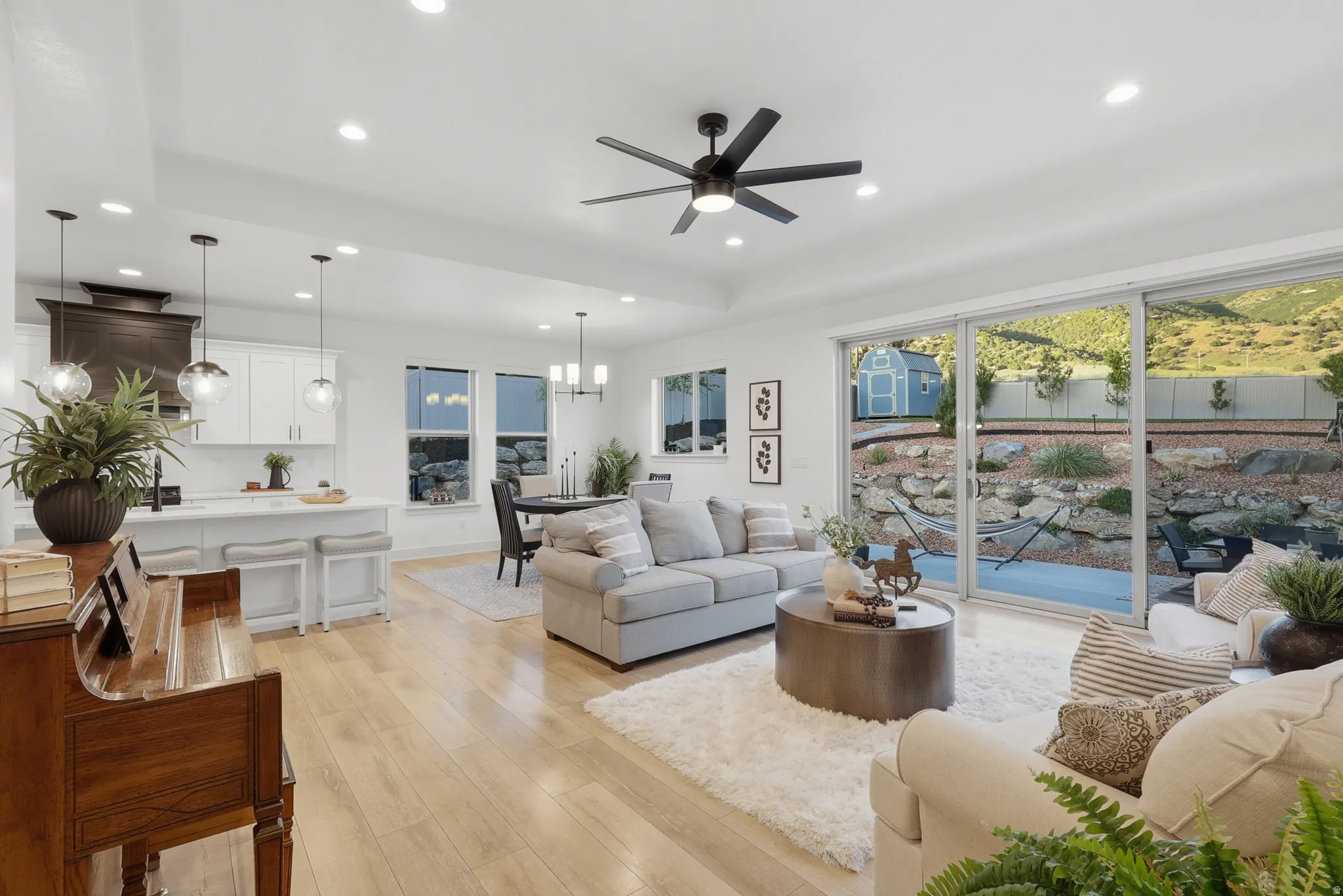 Open-concept living area featuring light wood-finish flooring, recessed lighting, and a modern ceiling fan