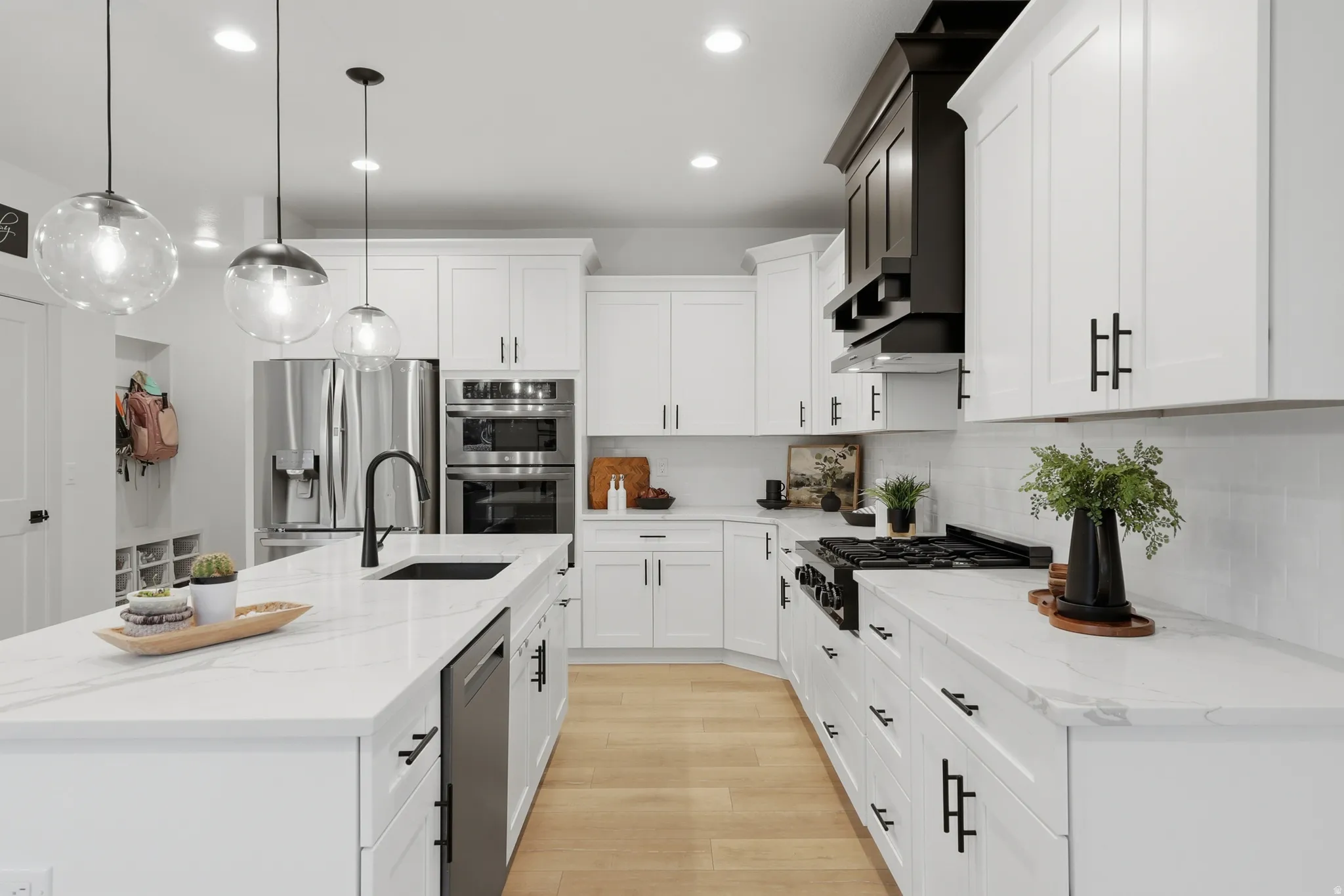 Contemporary kitchen with a spacious island featuring a black sink and matte black faucet