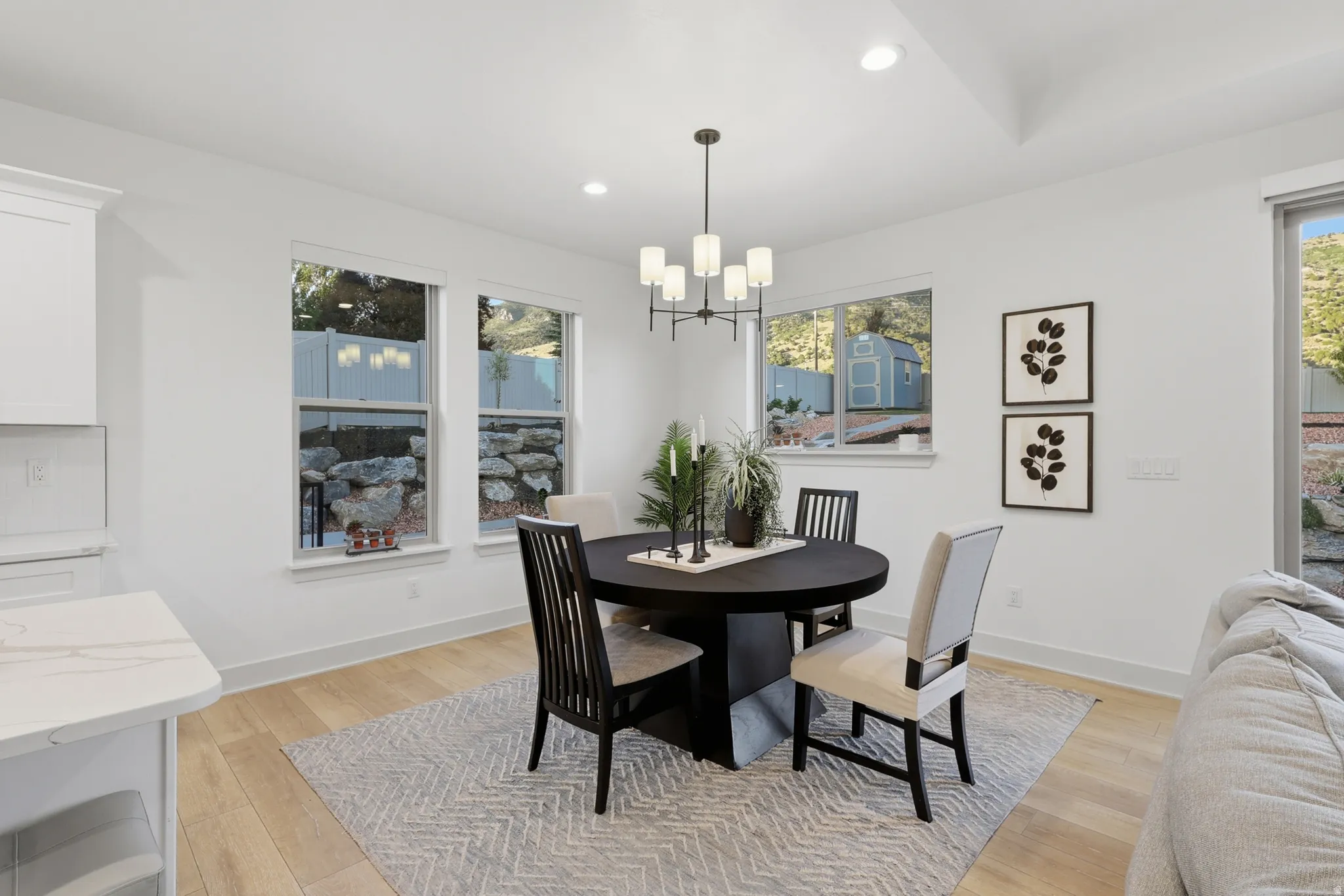 Dining area featuring light wood-finish flooring and a contemporary chandelier
