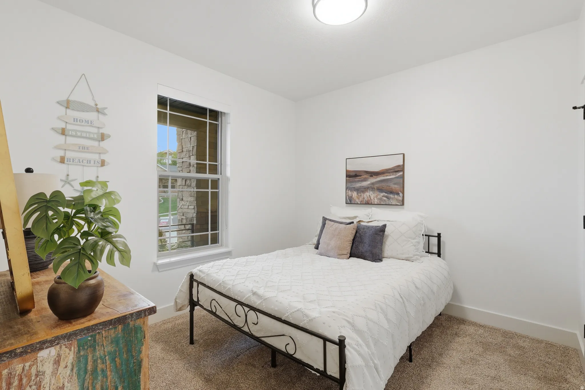 Bright room featuring a grid window, neutral carpeting, and a flush-mount ceiling light fixture