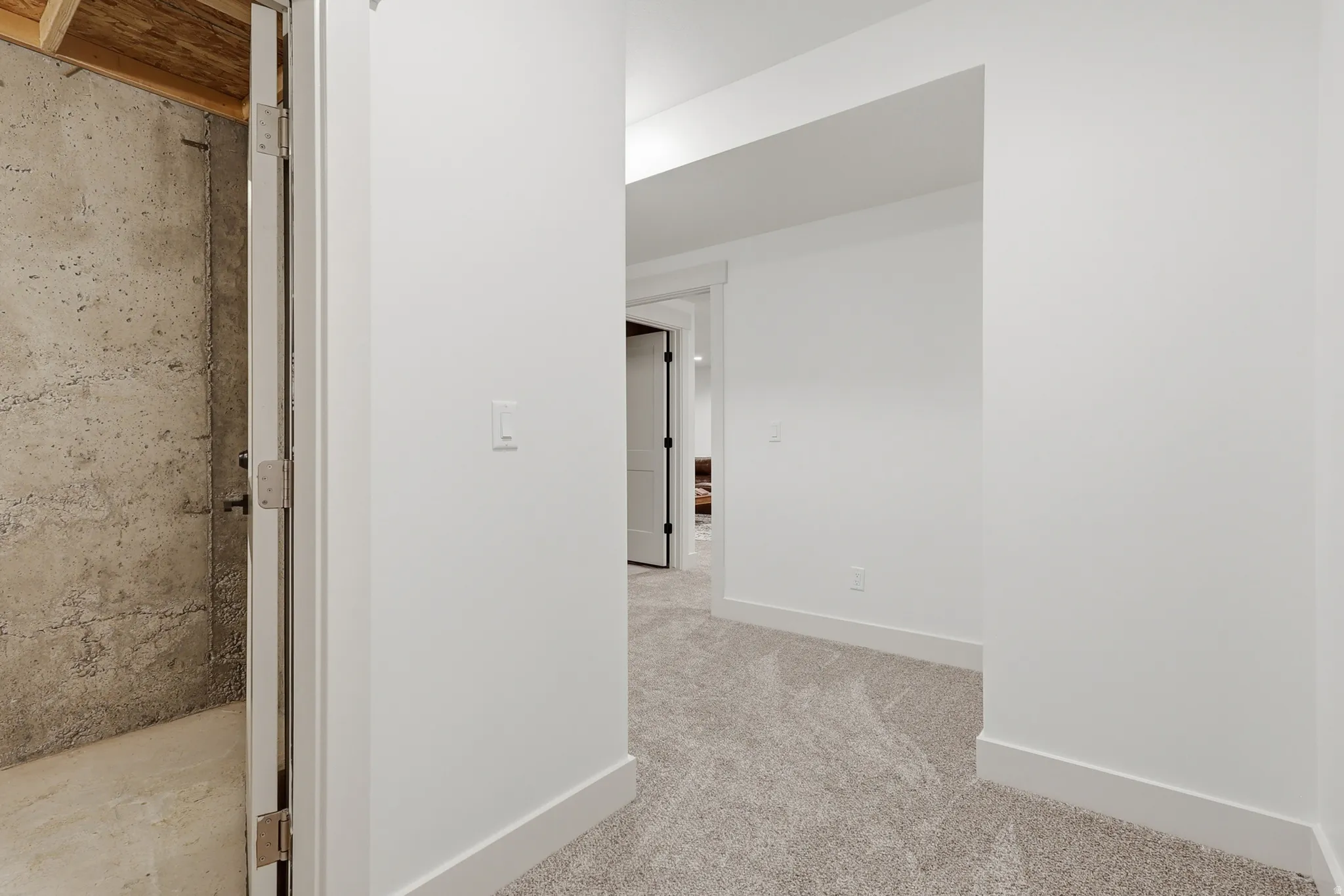 Hallway featuring light-toned carpet flooring, white walls, white trim, and recessed lighting