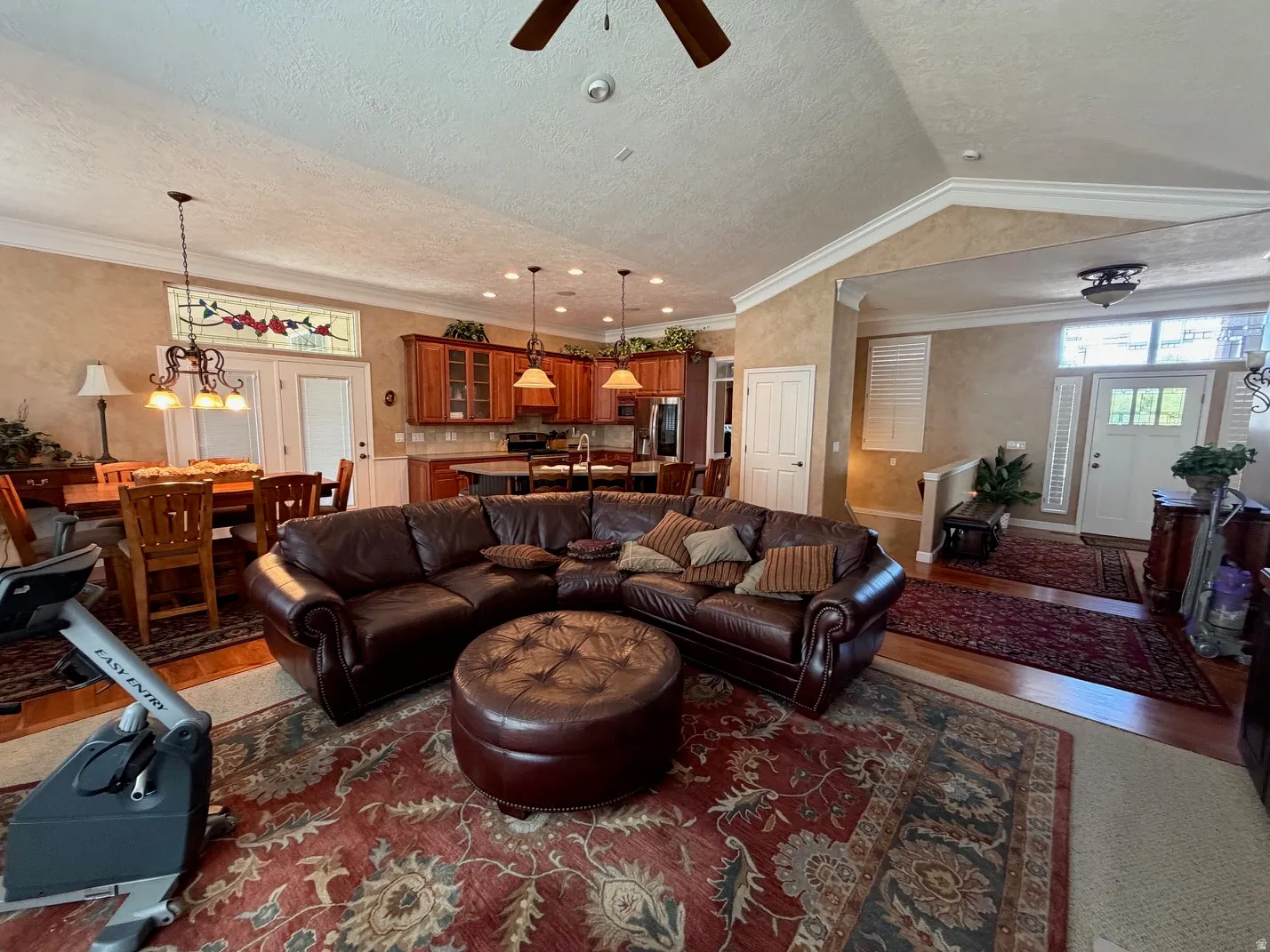 Open-concept living area with a vaulted ceiling and a ceiling fan