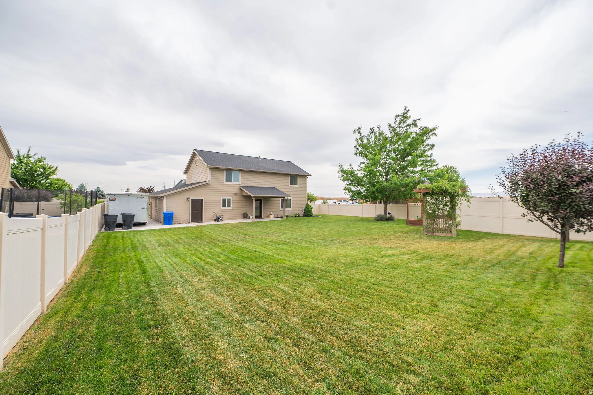 Expansive green lawn with a full vinyl fence enclosure