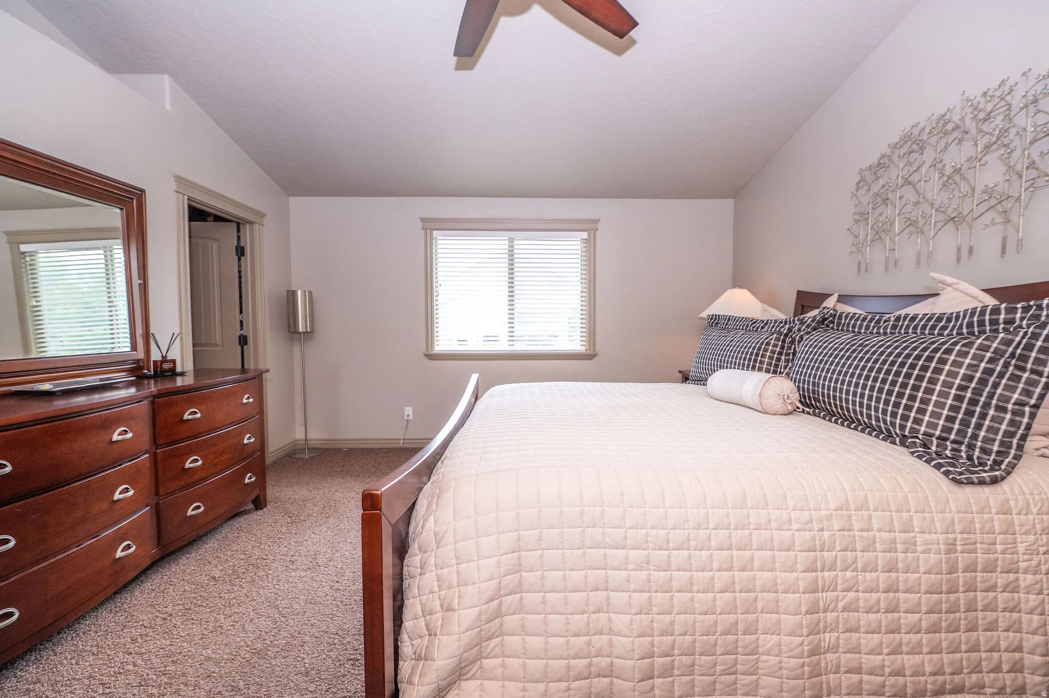 Carpeted bedroom featuring a ceiling fan, a window with blinds, and neutral wall tones