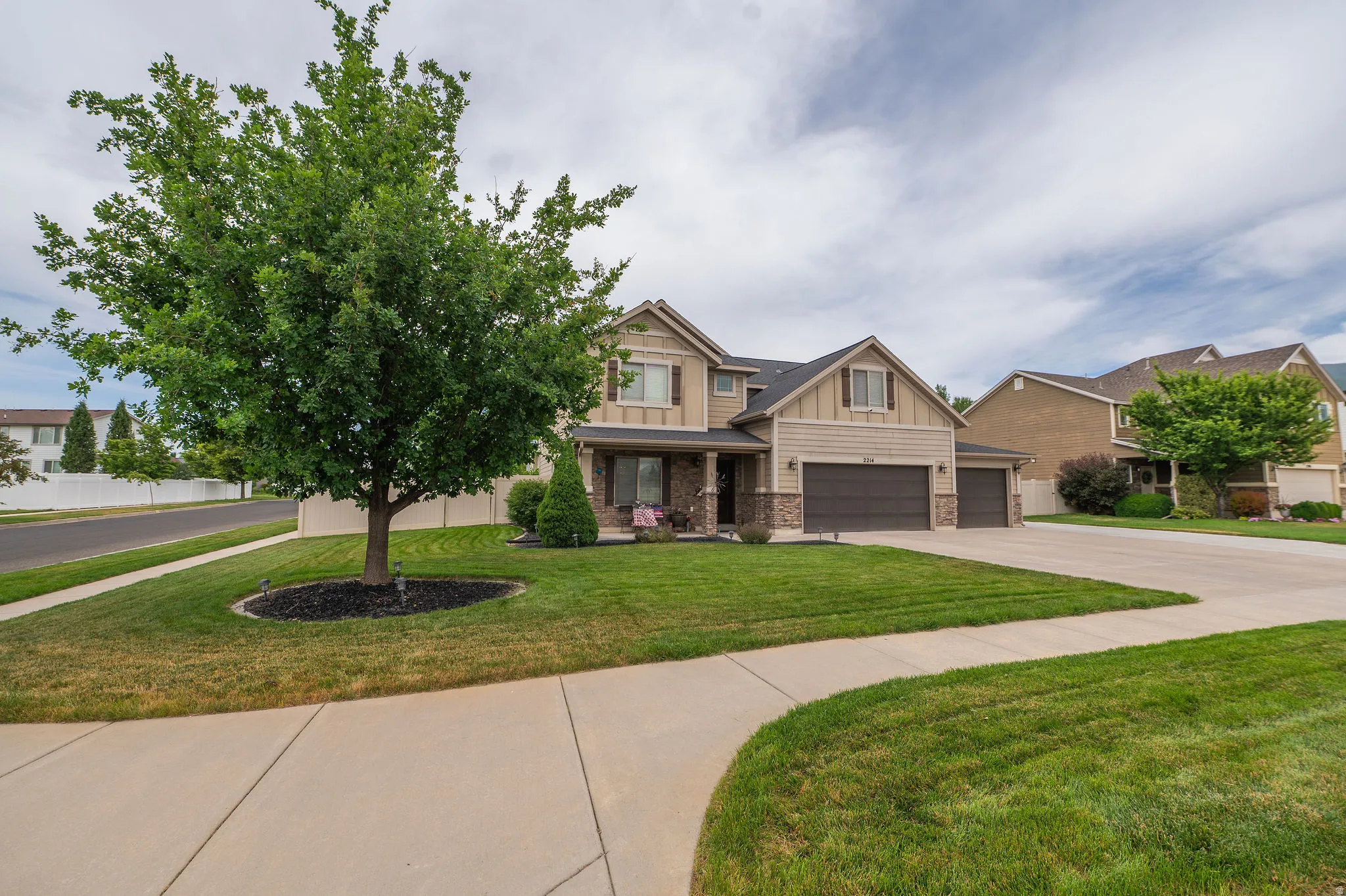 Two-story residence featuring a combination of siding and stone veneer, with a prominent front-facing gable