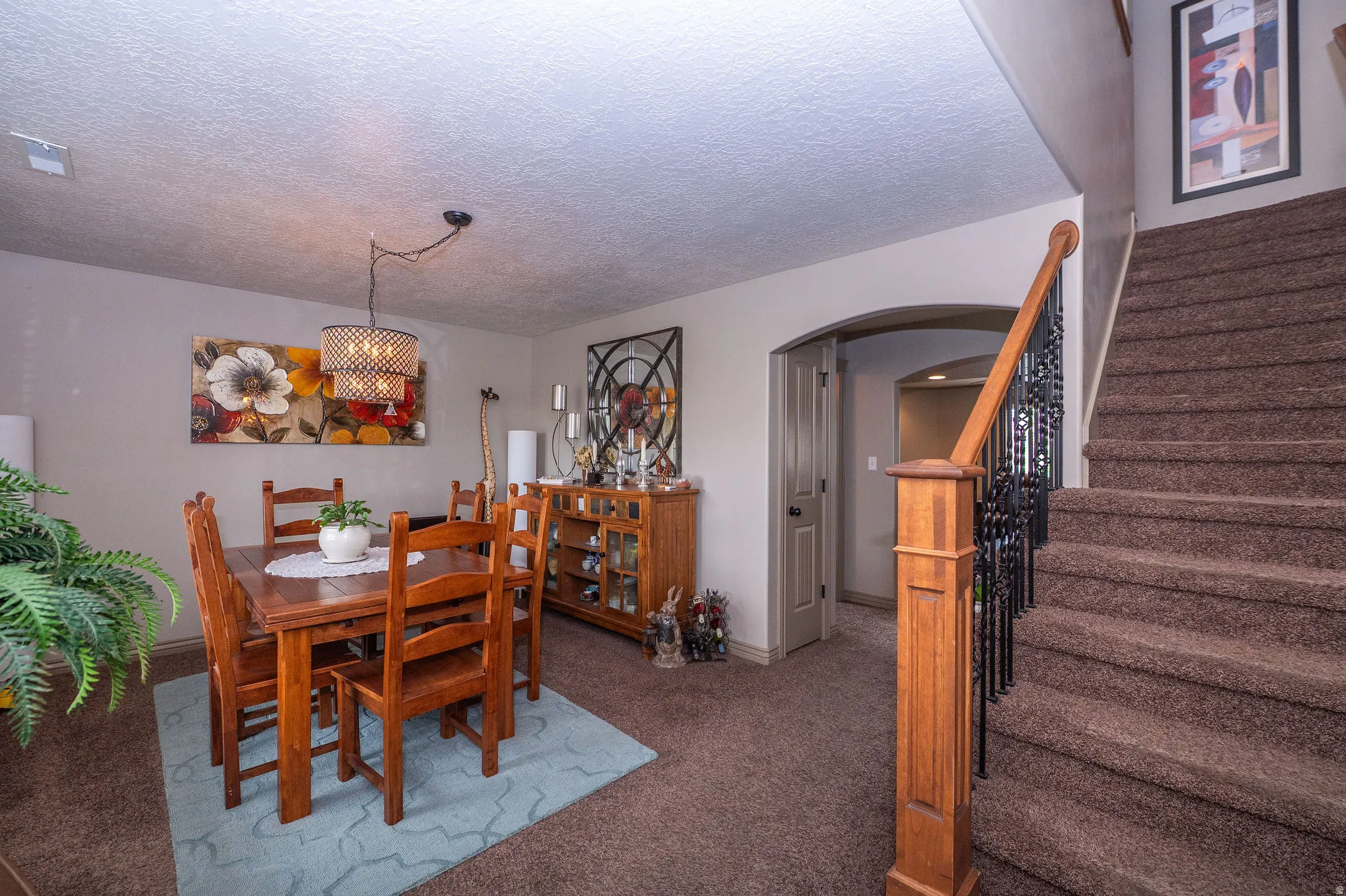 Carpeted staircase with an ornamental wrought iron and wood banister