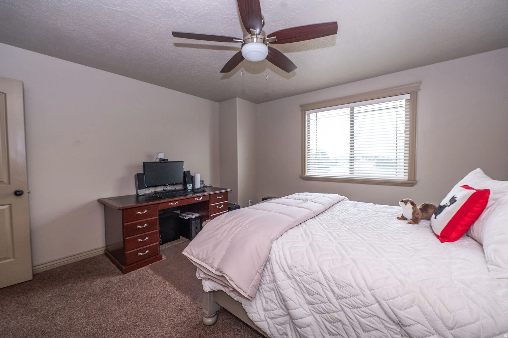 Bedroom featuring a ceiling fan, a window with blinds, and neutral carpet flooring