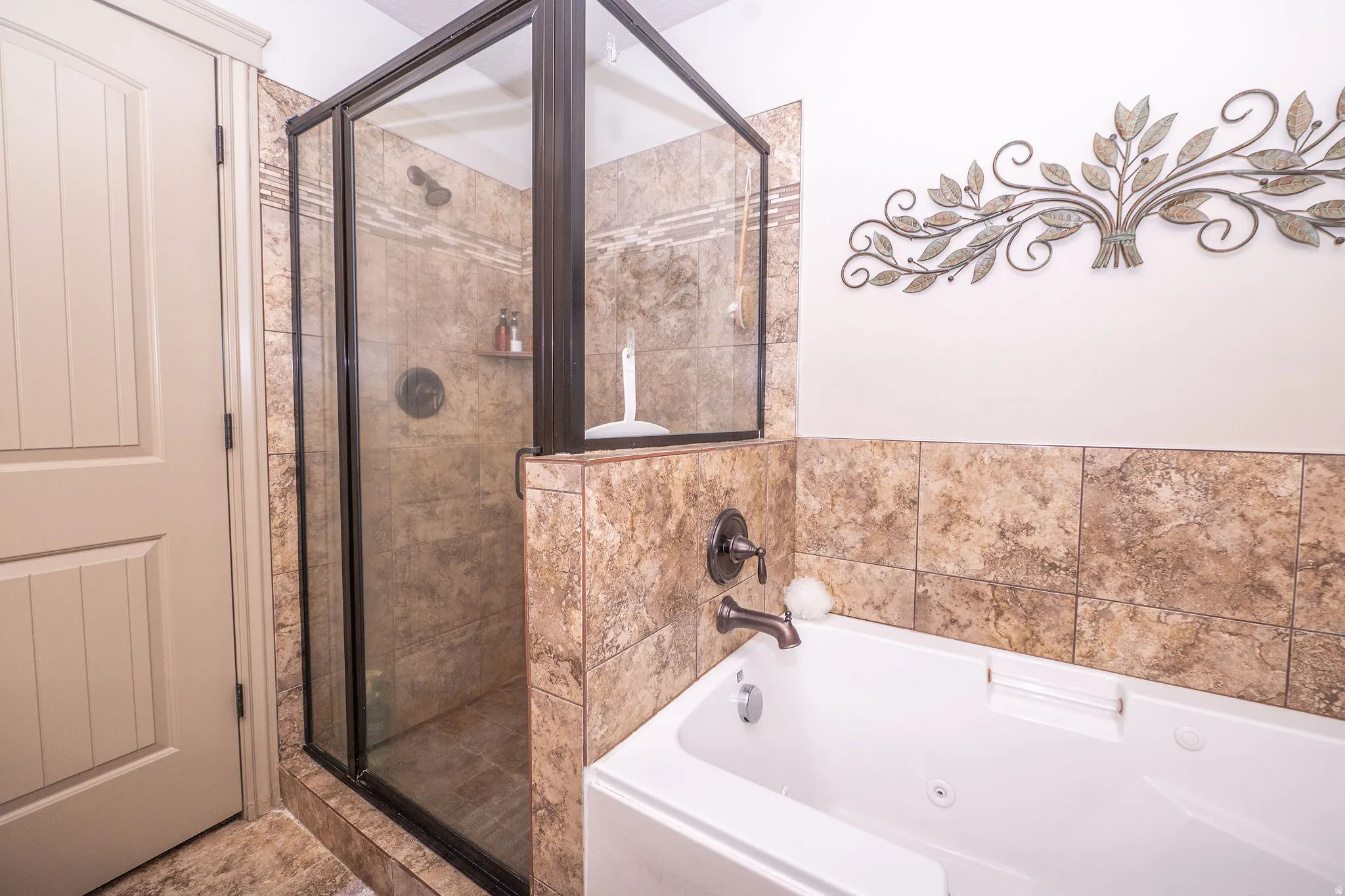 Tiled shower enclosure with a dark bronze frame and a built-in shelf
