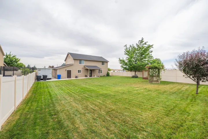Expansive green lawn with a full vinyl fence enclosure