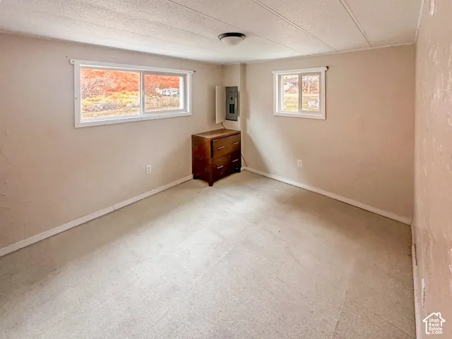 Neutral-toned room featuring two windows, light-colored flooring, and a flush-mount ceiling light fixture