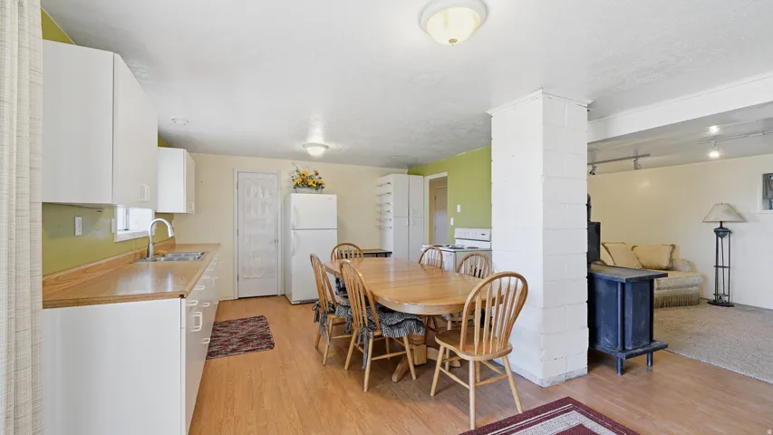 Kitchen area featuring white cabinetry, wood-finish countertops, and a stainless steel sink with a high-arch faucet