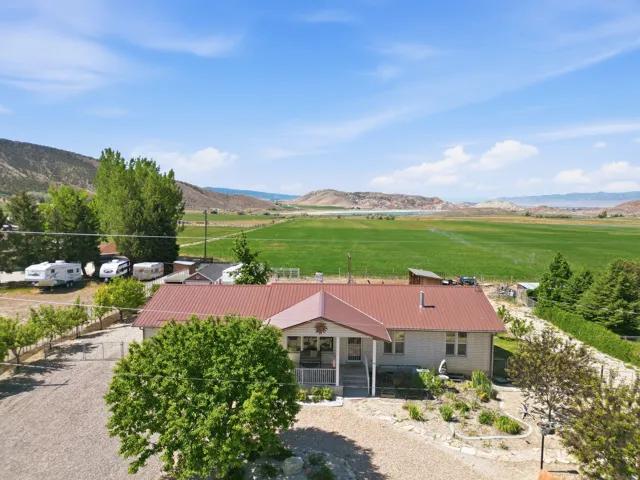 Ranch-style residence featuring a red metal roof and a gravel driveway