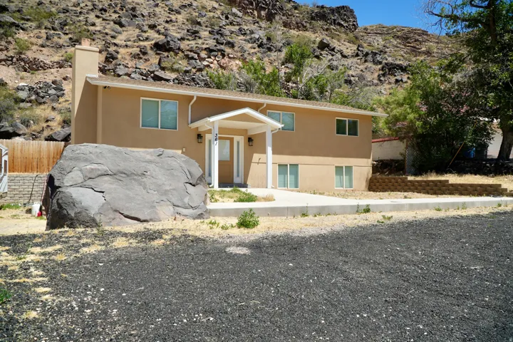 Two-story residence featuring a neutral stucco exterior and white trim