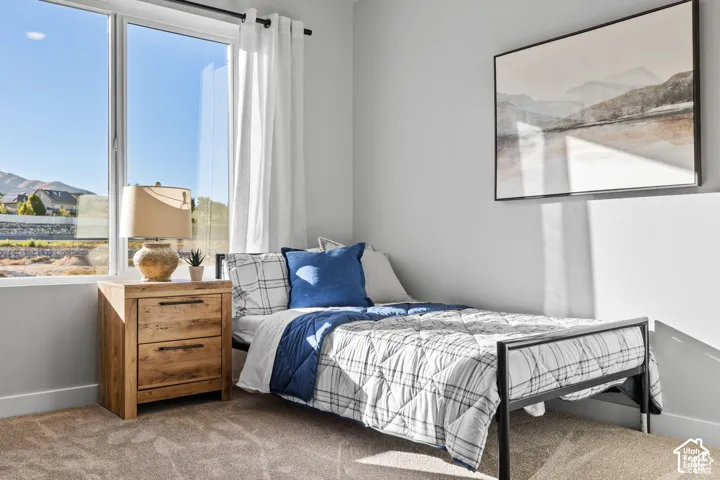 Bedroom featuring a large picture window, neutral wall paint, and carpet flooring