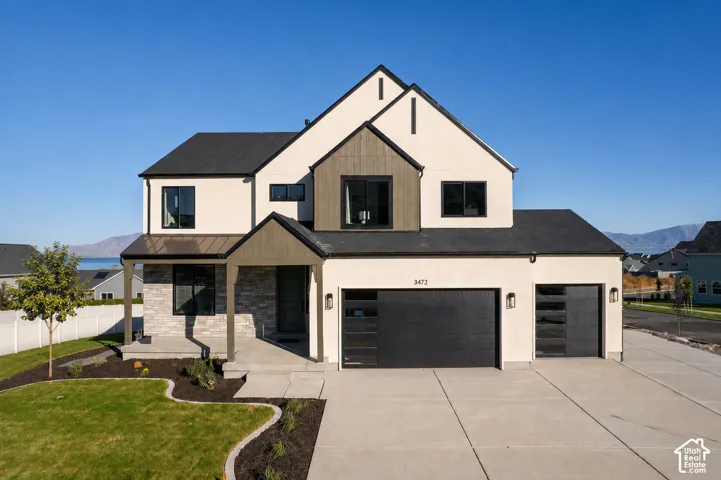 Modern residential architecture featuring a light-toned stucco facade with dark accents