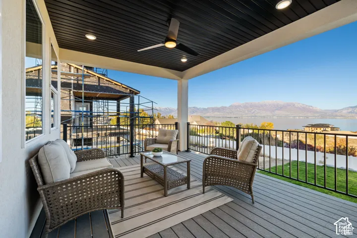 Covered patio featuring composite decking and a black metal railing