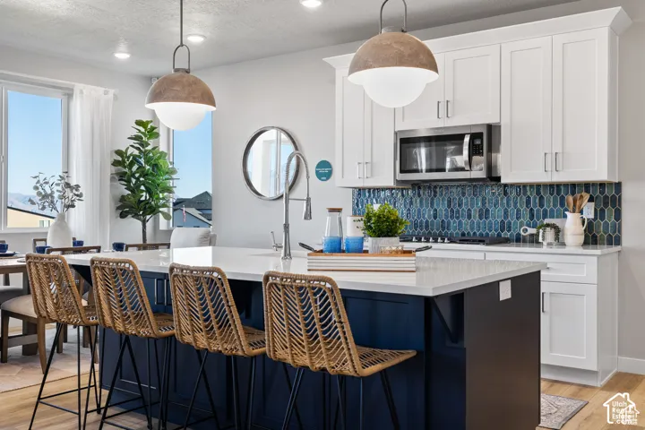 Kitchen featuring an expansive island with a white countertop and blue base cabinetry