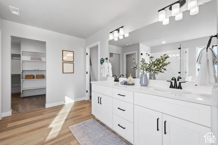Double vanity with white cabinetry, matte black fixtures, and a large wall-mounted mirror