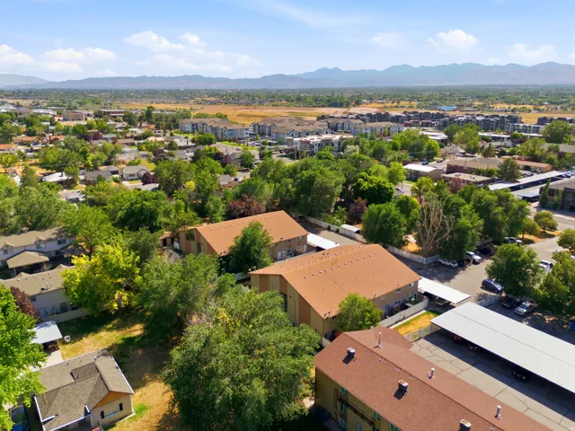 Expansive residential area featuring a mix of housing types, abundant mature trees, and covered parking structures