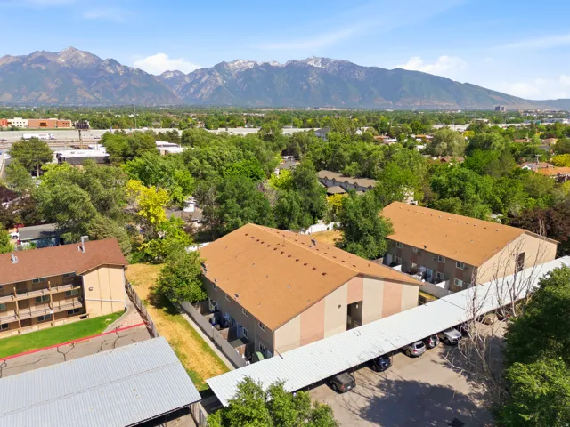 Aerial perspective showcasing multiple properties with mountain backdrops and covered parking structures