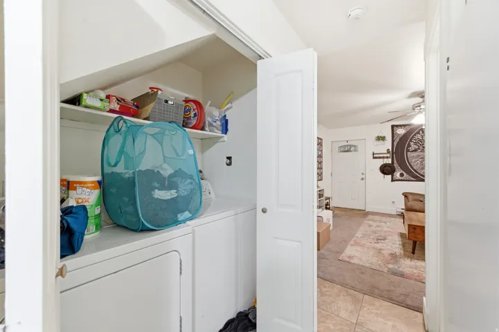Dedicated laundry area featuring a built-in shelf and integrated appliances