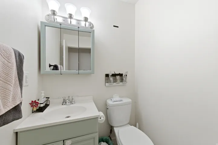 Half Bath with a vanity and light green cabinetry