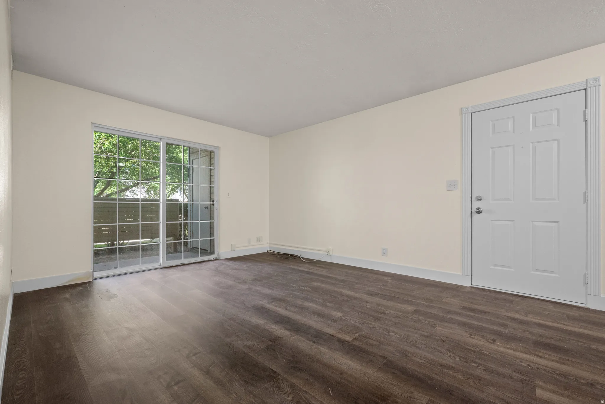 Living space featuring wood-finish flooring, light-toned walls, and white trim