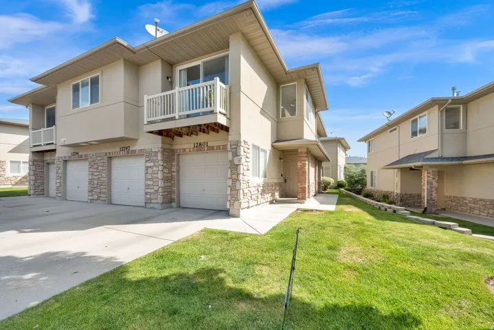 Multi-unit residential building featuring stucco and stone veneer siding