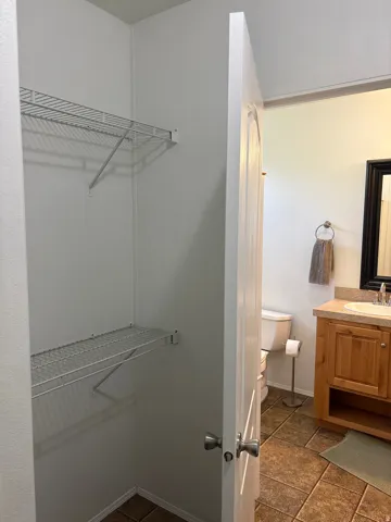 Walk-in closet with wire shelving and durable tile flooring