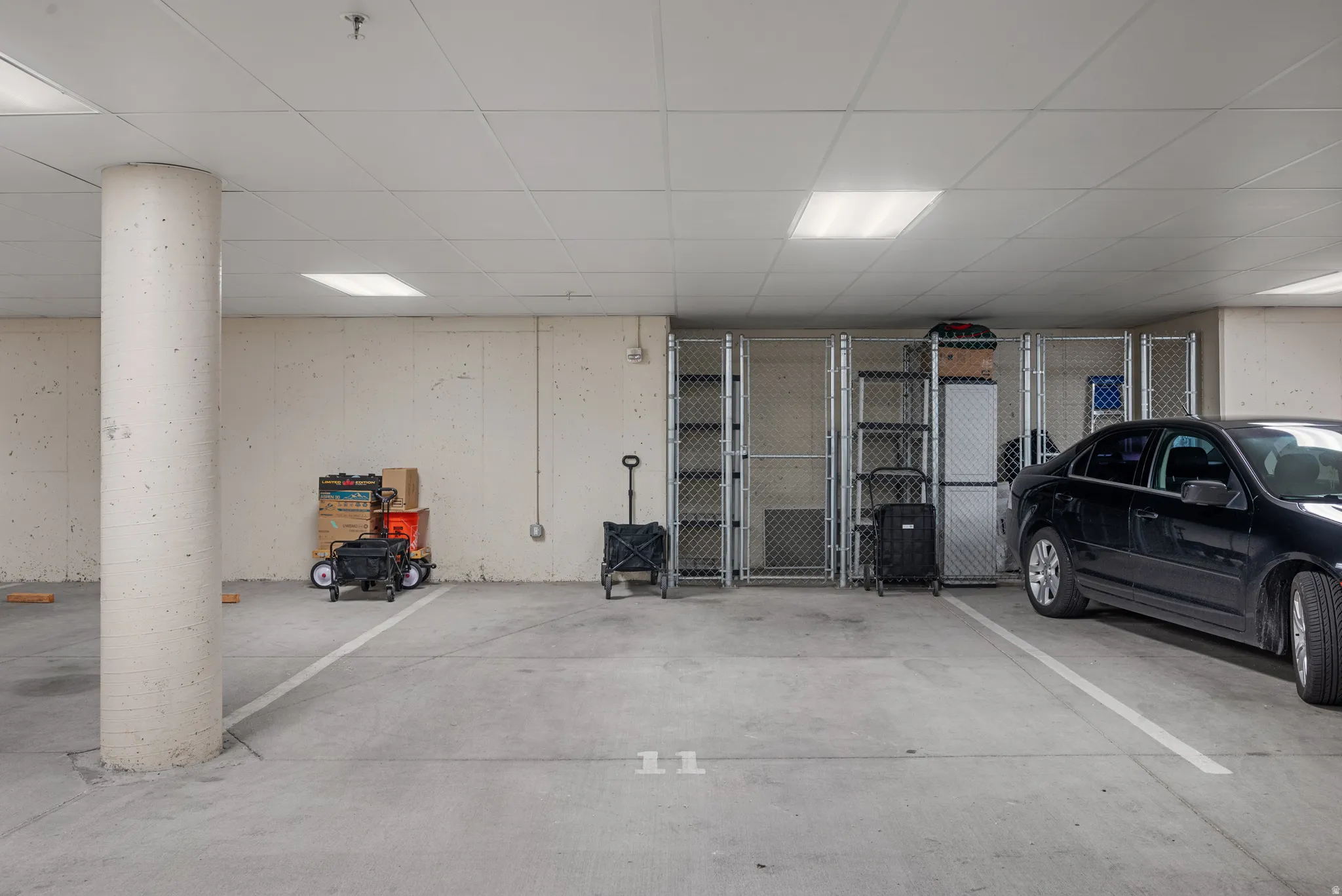 Dedicated parking space featuring concrete flooring, a support column, and overhead lighting